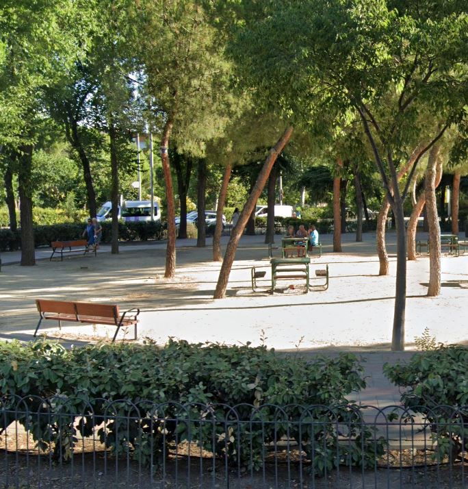 Imagen de un parque urbano con algo de mobiliario tradicional de madera.