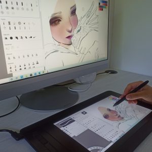 Tableta gráfica con pantalla con un dibujo y ordenador con el mismo dibujo