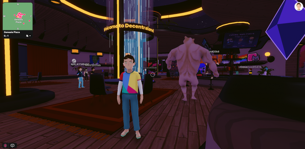 Sala de bienvenida de Decentraland en la que se ve el avatar del jugador, varios avatares mas de fondo y un cartel de bienvenida.